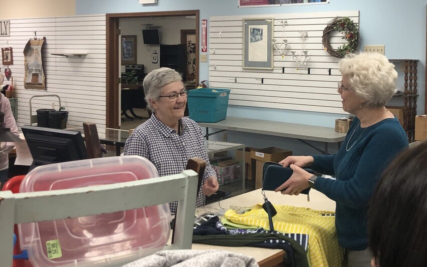 Two women chatting while volunteering at The Depot Thrift Shop.