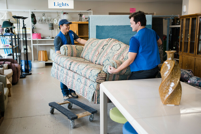 Father and son volunteer duo do some lift a couch.