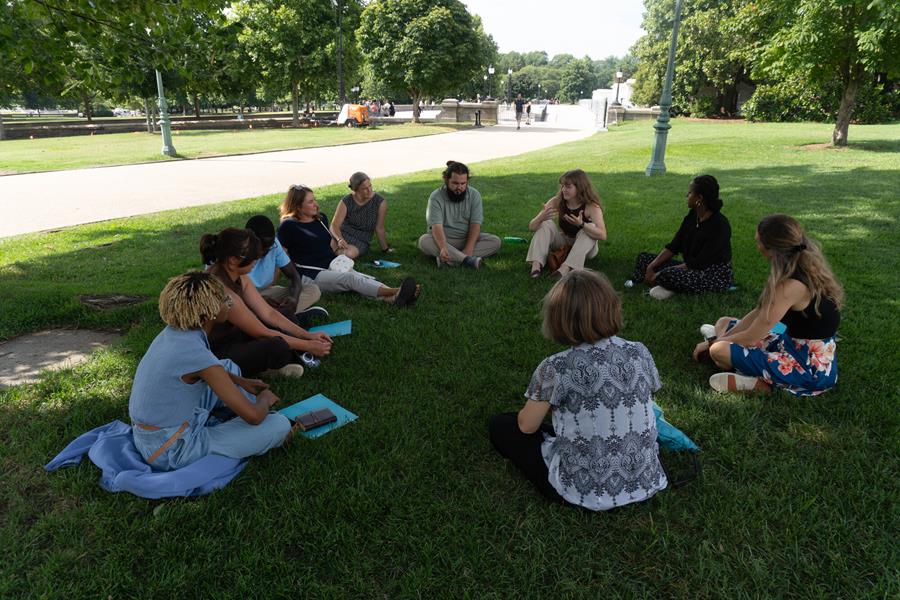 Climate campaign participants sitting in a circle in a field.