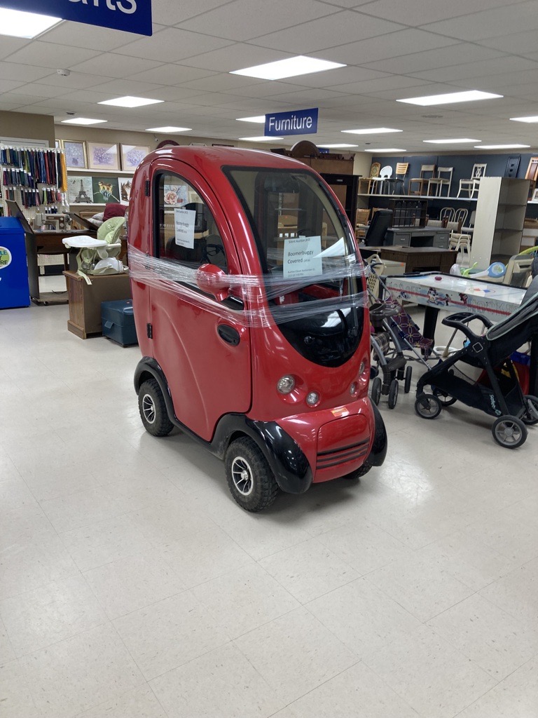 Boomber buggy in red on the floor of an MCC Thrift shop.