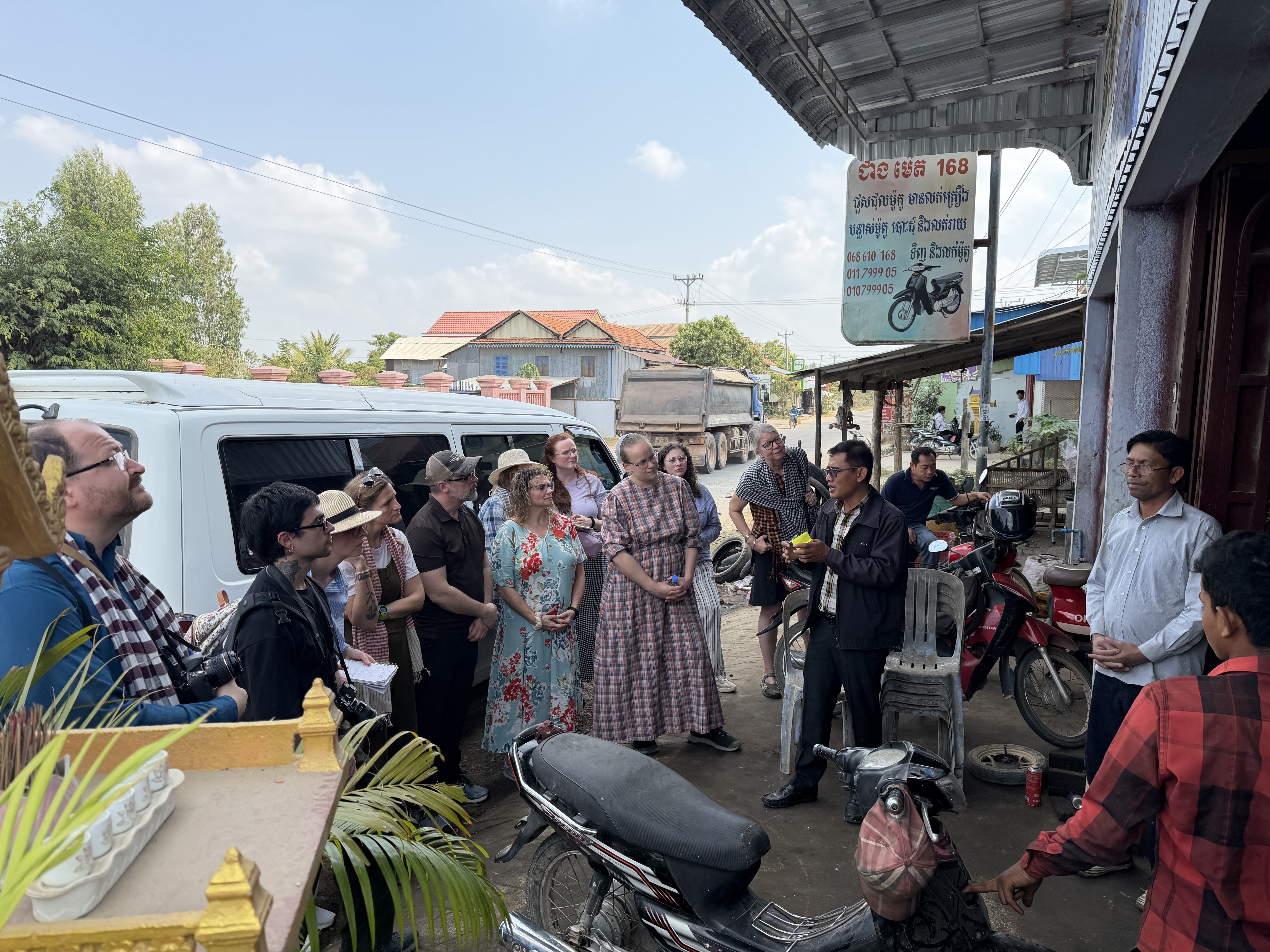 Group photo at a motorcycle repair shop