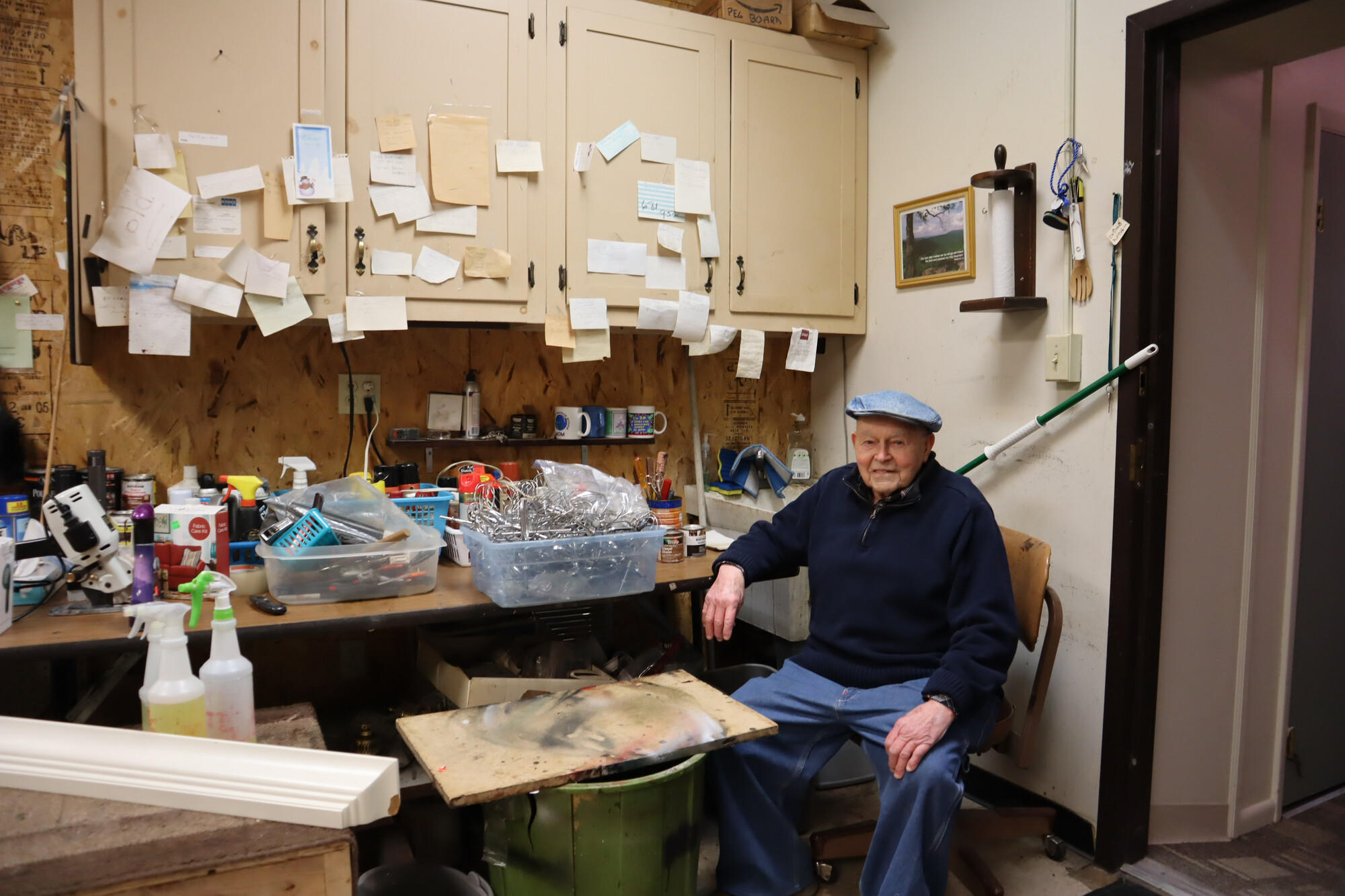 Nelson Hershey sits in his favorite chair in the workroom at Columbia Re-Uzit Shop. Six days a week, he eats his lunch here: a ham and cheese sandwich and a cup of applesauce.