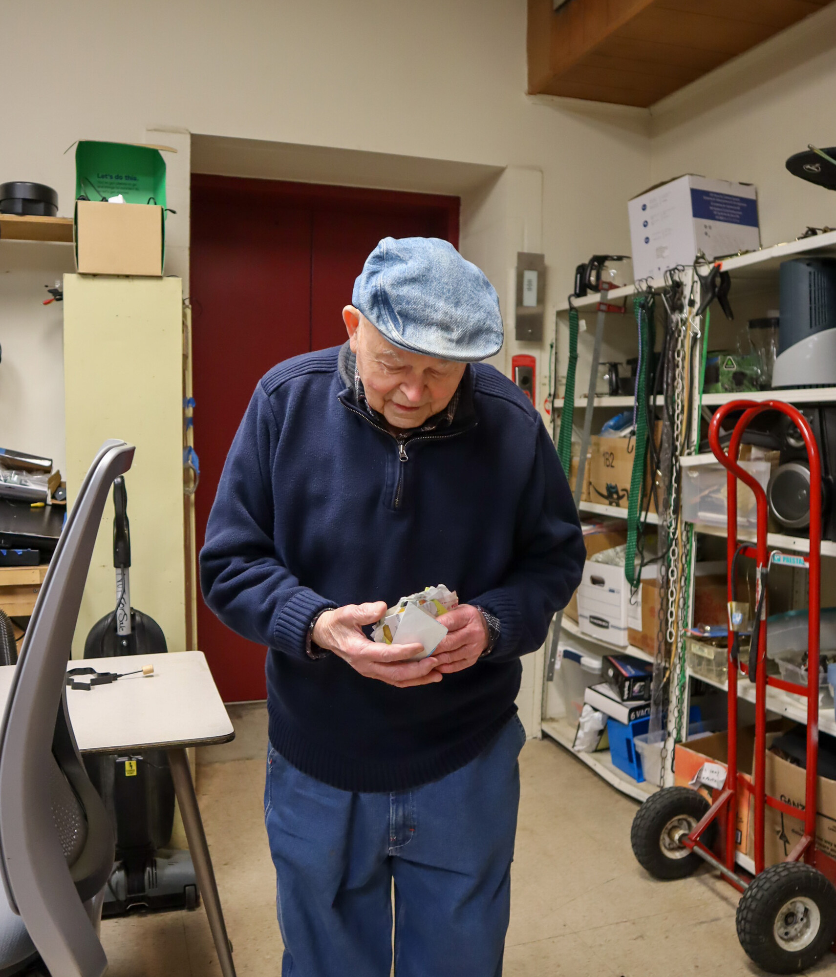 In the workroom at Columbia Re-Uzit Shop, co-founder and longtime volunteer Nelson Hershey pulls his “rolodex” of important contacts out of his pocket.