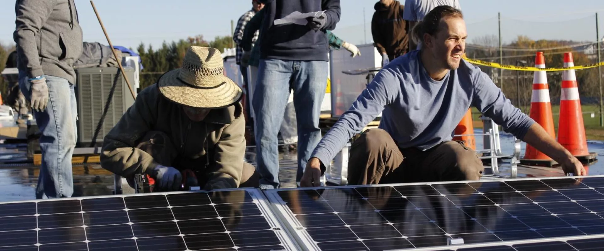 A group of volunteers lay solar panels on the rooftop of the Gift & Thrift MCC Thrift Shop in Harrisonburg,Virginia.