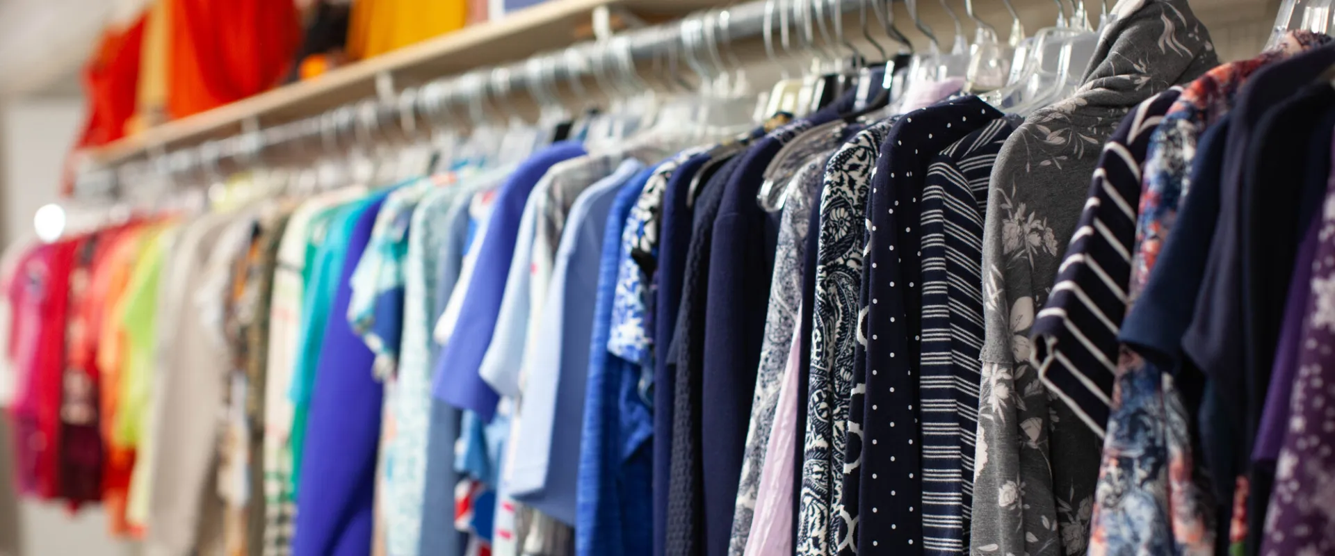 A rack of shirts sorted by color.