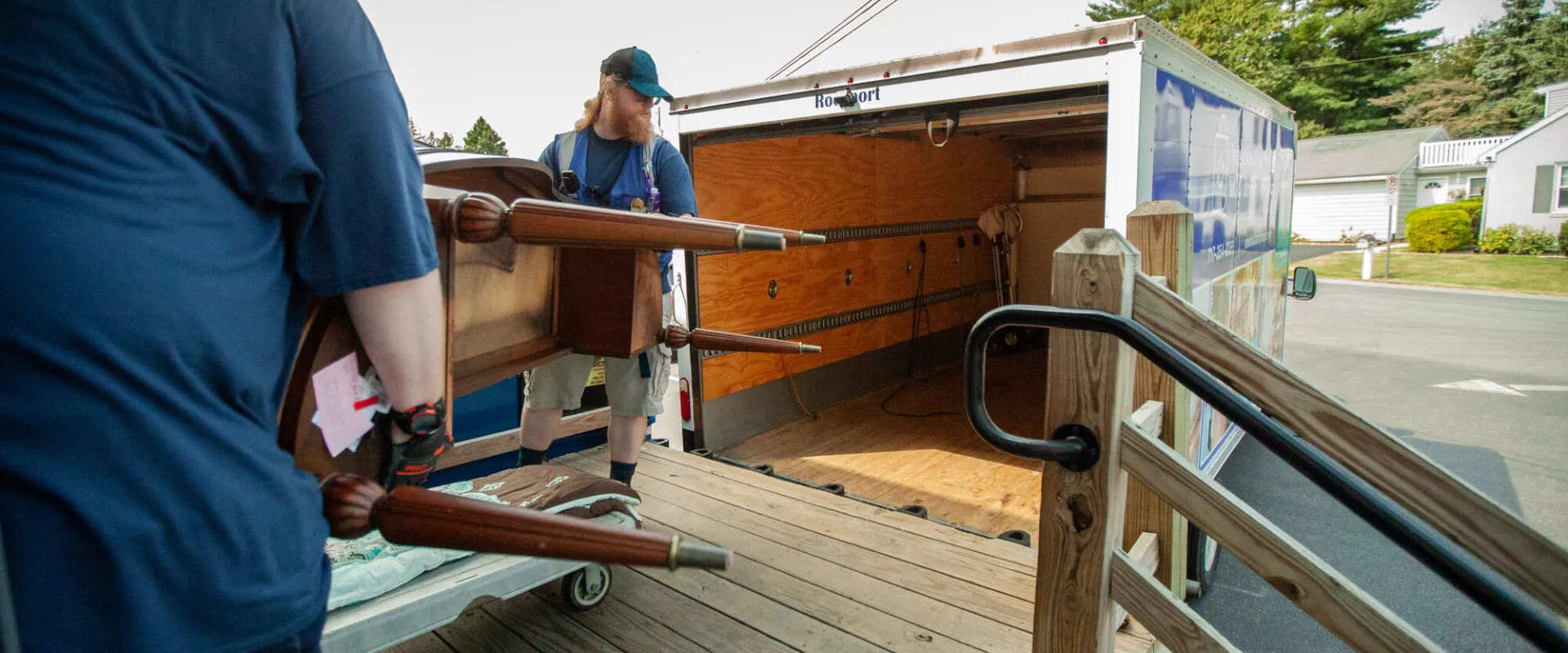 Two men loading a truck with donated furniture.