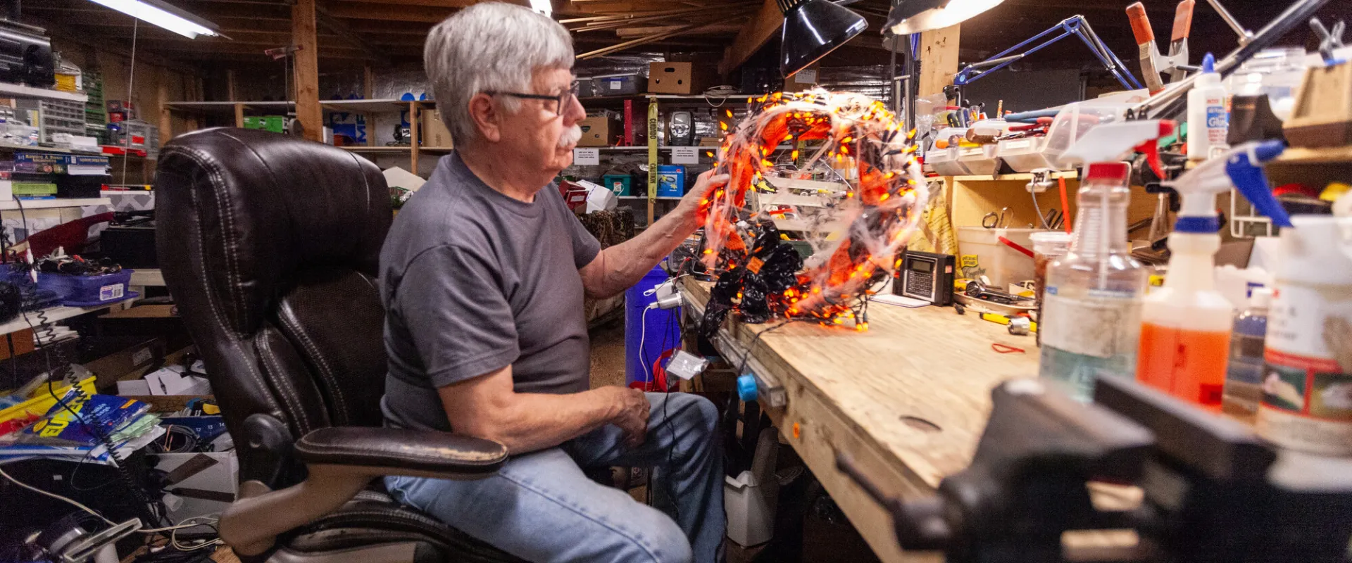 Older man volunteering by fixing damaged thrift items.