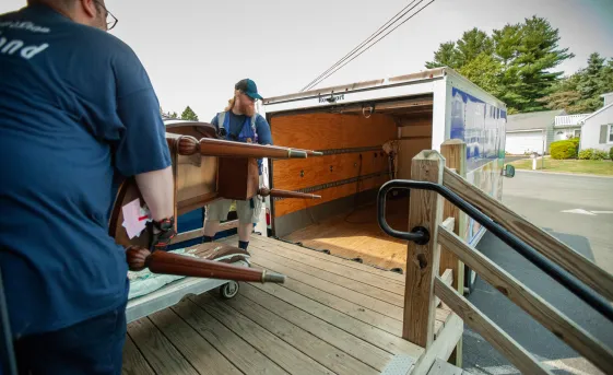 Two men loading a truck with donated furniture.
