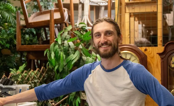 Volunteer Leo standing backroom in a thrift shop.