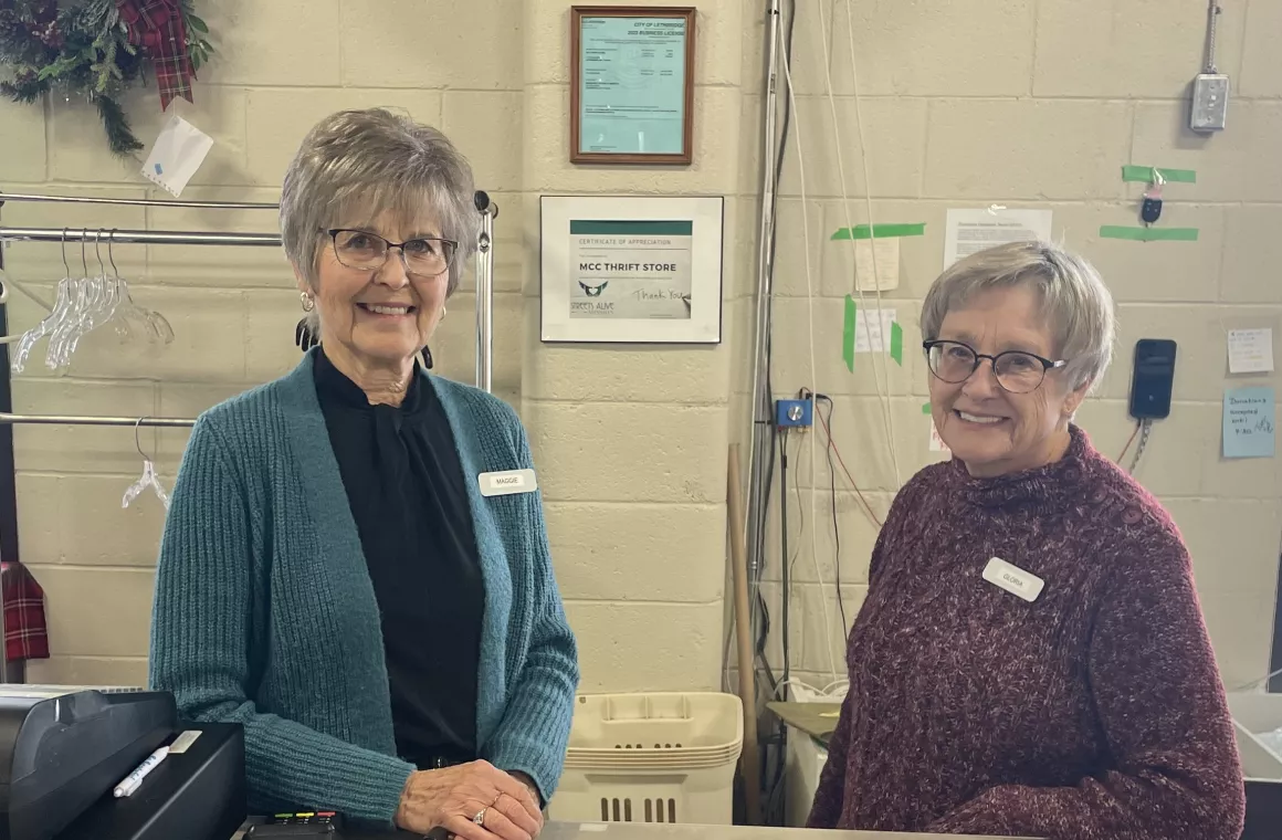 Two volunteers standing at a cash desk