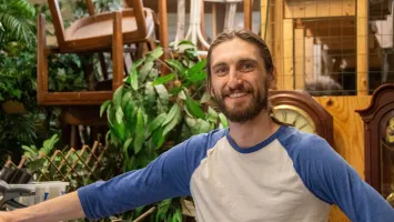 Volunteer Leo standing backroom in a thrift shop.